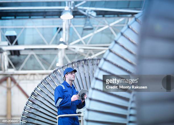 engineer inspecting steam turbine in repair bay - power station stock pictures, royalty-free photos & images