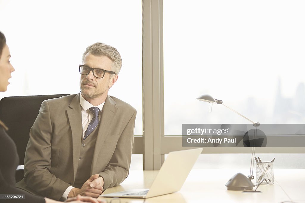 Businessman interviewing young female candidate in office