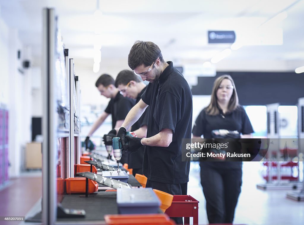 Apprentices working on training production line