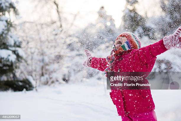 young girl shouting and throwing snow mid air - day toronto stock-fotos und bilder