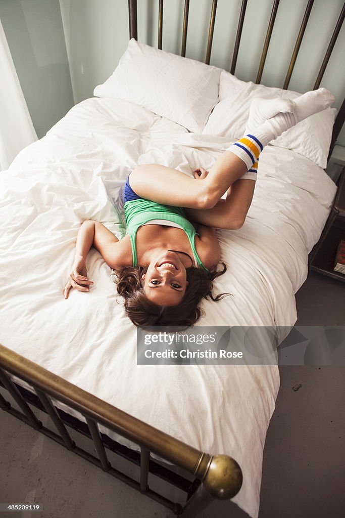 Young woman lying on bed, high angle