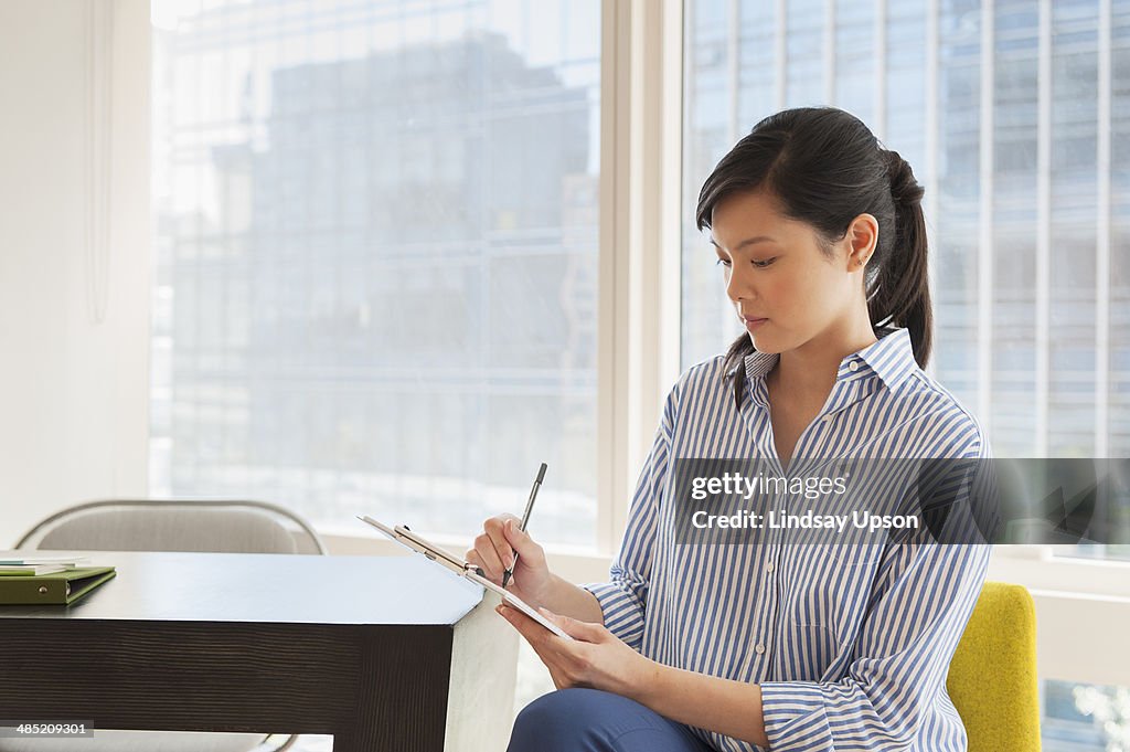 Young businesswoman working on paperwork in office