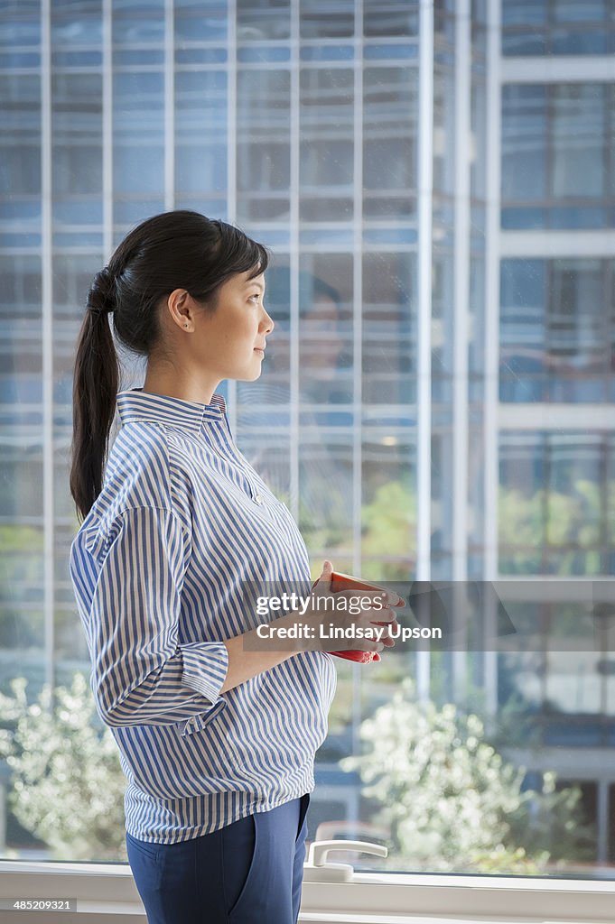 Portrait of young businesswoman looking out of window