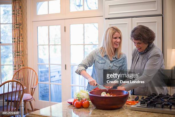 senior woman and granddaughter preparing salad - gran londres stock pictures, royalty-free photos & images