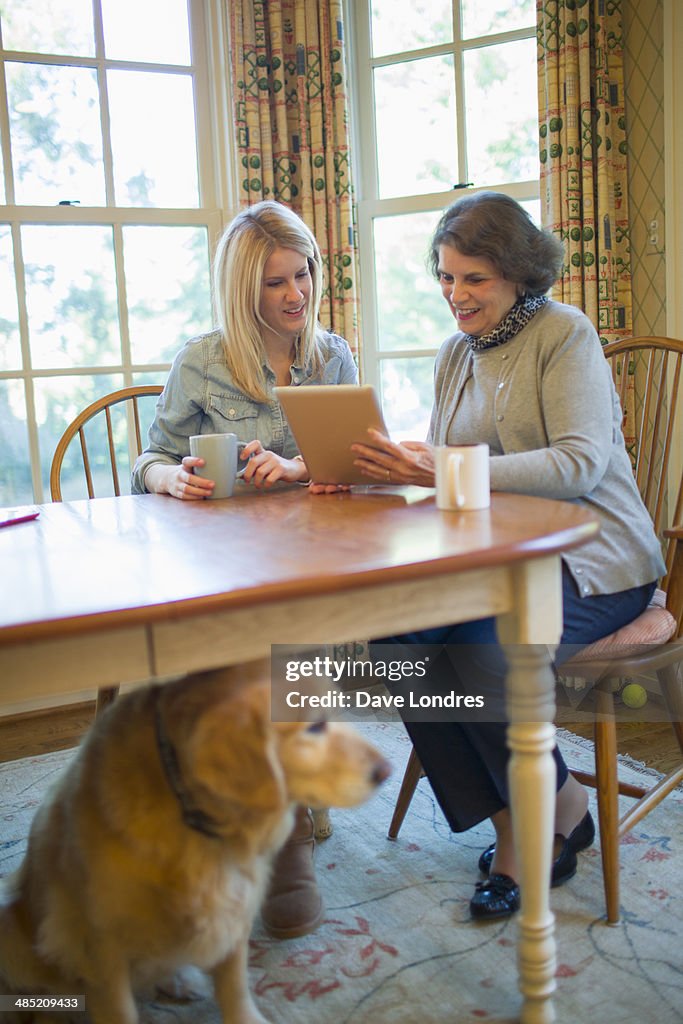 Senior woman and granddaughter using digital tablet
