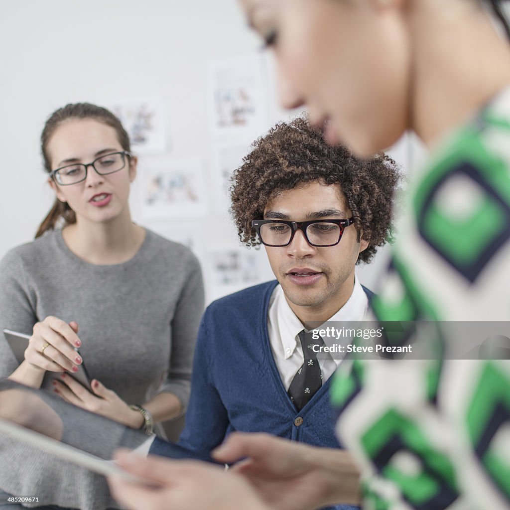 Three colleagues using digital tablet