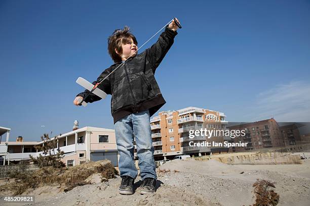 boy at the coast preparing to fly toy airplane, long beach, new york state, usa - long beach new york stock pictures, royalty-free photos & images