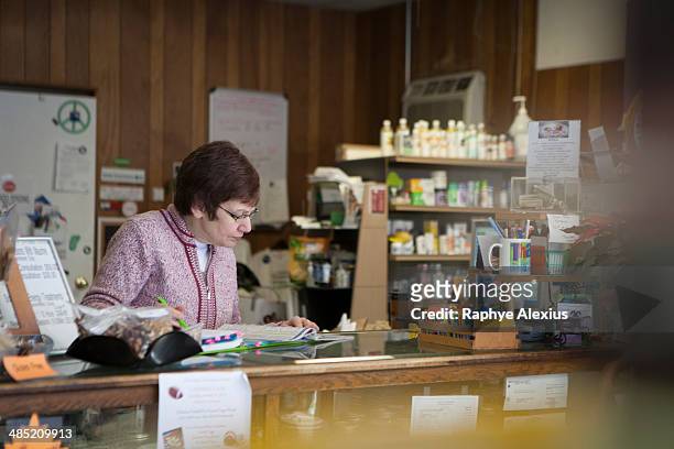 health foods store owner working at counter - monroe michigan - fotografias e filmes do acervo
