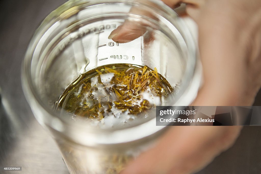 Making a remedy with calendula and olive oil in health foods store