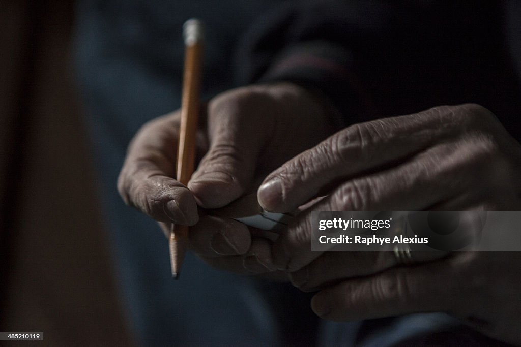Close up of male hands holding a pencil and piece of wood