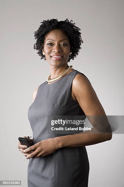 businesswoman holding smartphone - gray dress imagens e fotografias de stock