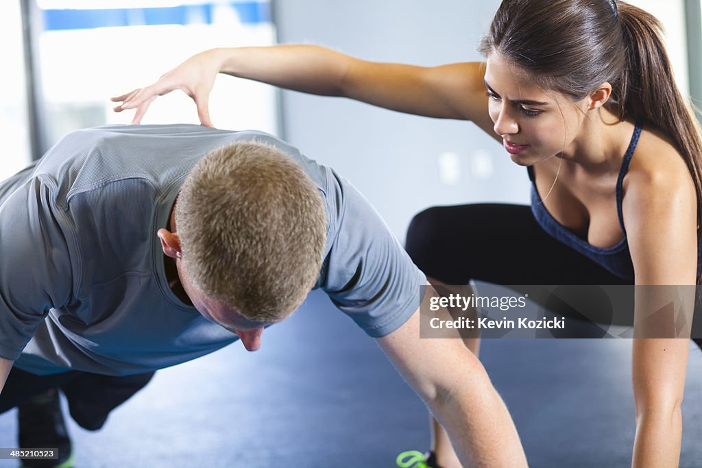 Couple helping each other in gym