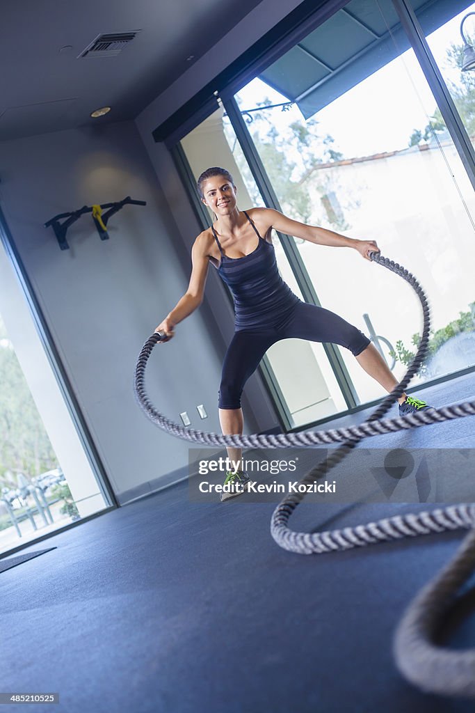Young woman working out with rope