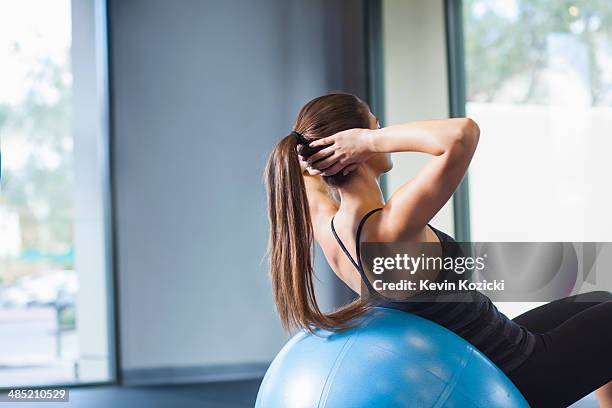 young woman working out with gym ball - yoga ball stock pictures, royalty-free photos & images