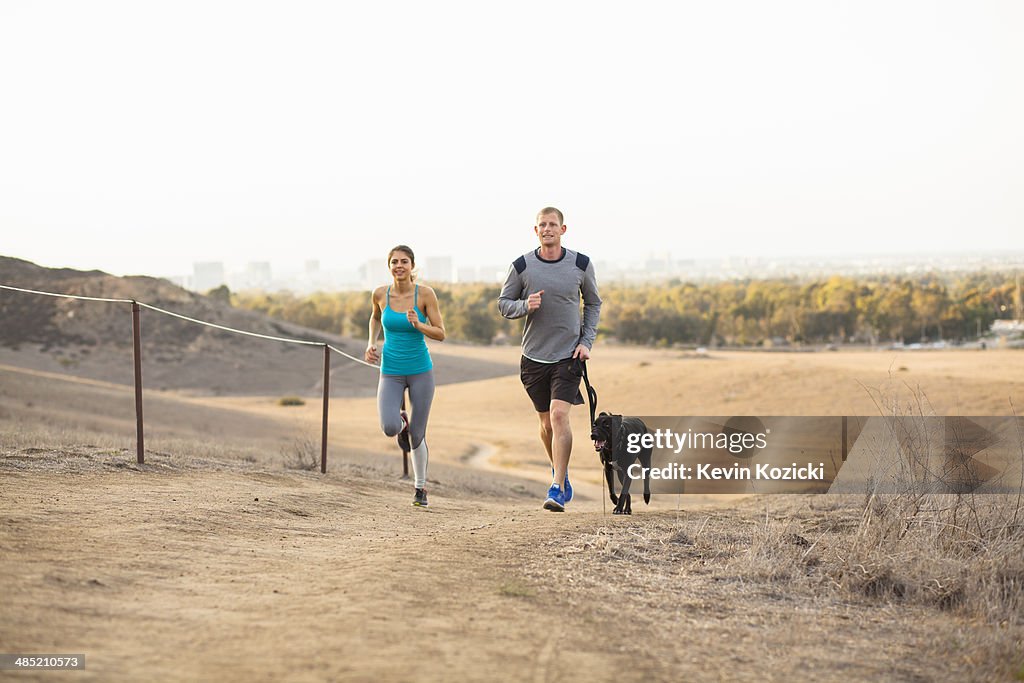 Couple running with dog