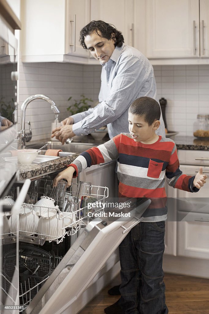 Boy helping father in kitchen
