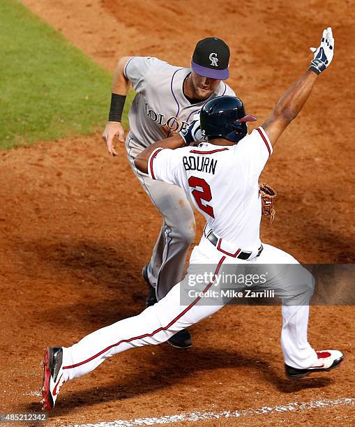 Michael Bourn of the Atlanta Braves is tagged out by first baseman Ben Paulsen of the Colorado Rockies in the third inning during the game at Turner...