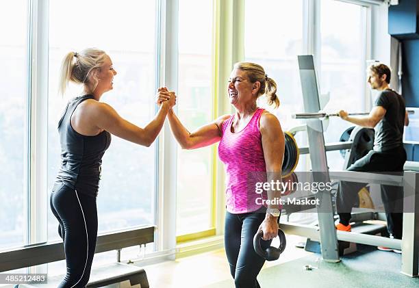 happy women at health club - hi five gym stockfoto's en -beelden