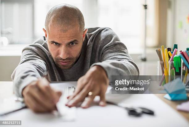 businessman drawing line on paper at desk in creative office - ruler stock-fotos und bilder