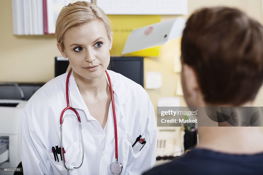 Young female doctor with male patient in clinic