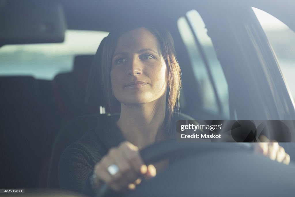 Young businesswoman driving car