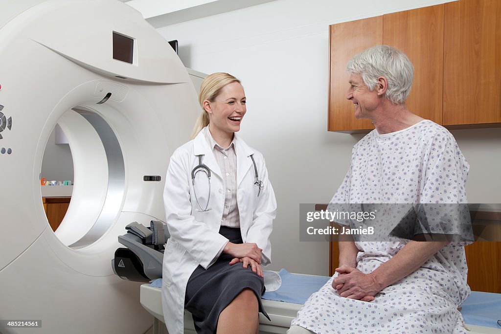 Doctor talking to male patient in hospital scanning room