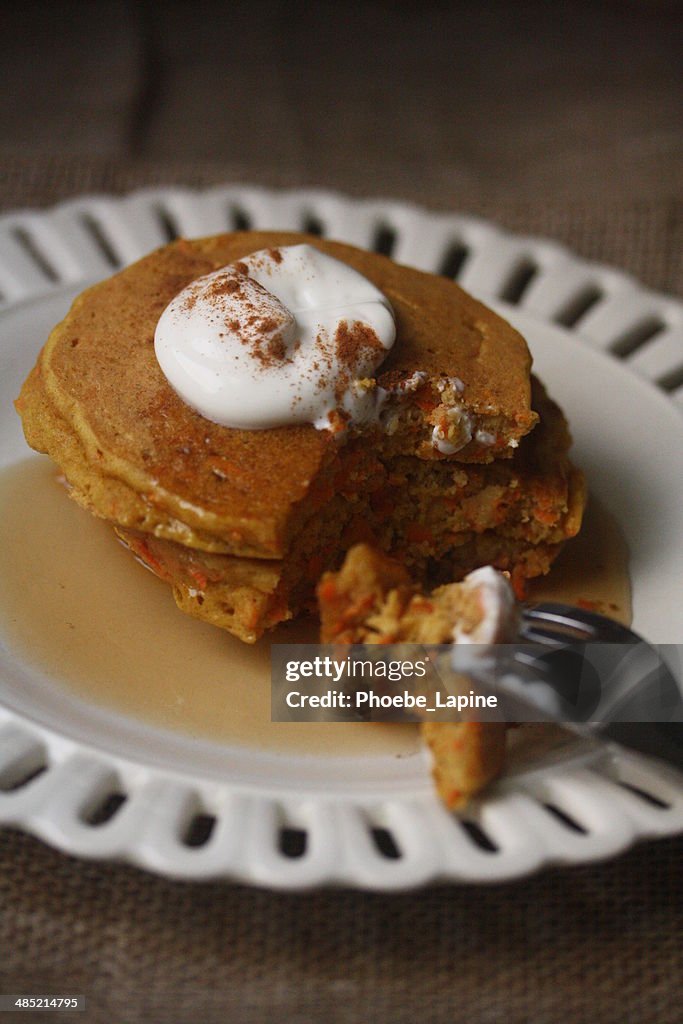 Carrot cake pancakes with yogurt, warm maple syrup and cinnamon