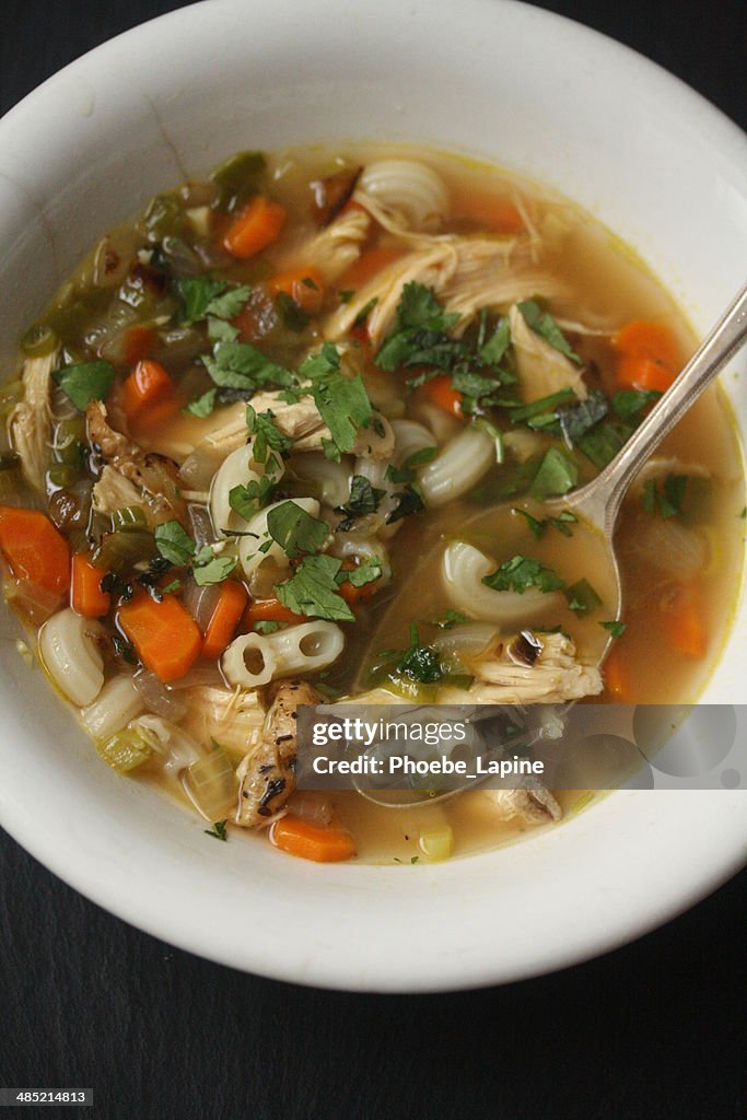 Bowl of turkey noodle soup with ginger and cilantro