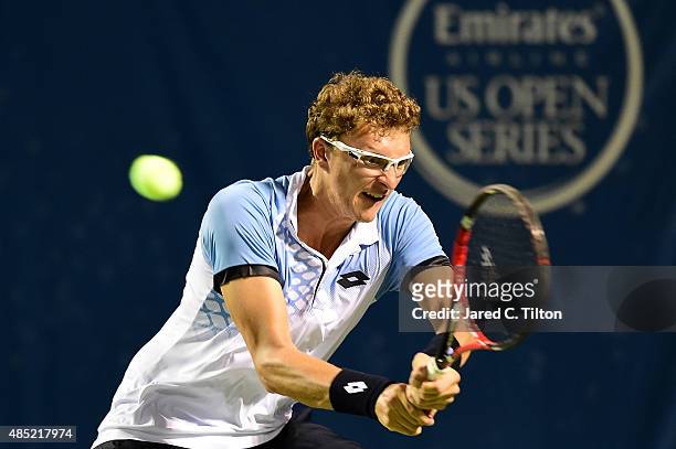Denis Istomin of Uzbekistan returns a shot from Jo-Wilfried Tsonga of France during the second day of the Winston-Salem Open at Wake Forest...