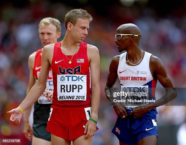 Galen Rupp of the United States and Mohamed Farah of Great Britain chat after competing iin the Men's 5000 metres heats during day five of the 15th...