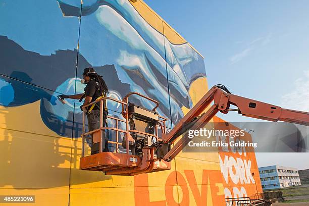 Brandan "BMike" Odums nears completion of The Wall of Peace mural at The Grand Theater on August 25, 2015 in New Orleans, Louisiana. The timing of...
