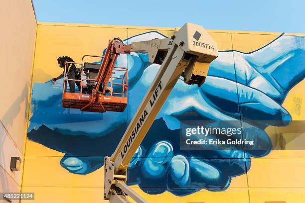 Brandan "BMike" Odums nears completion of The Wall of Peace mural at The Grand Theater on August 25, 2015 in New Orleans, Louisiana. The timing of...