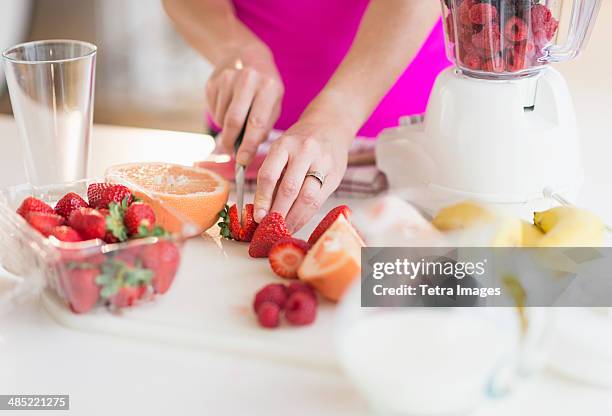 woman slicing strawberries - smoothie home stock pictures, royalty-free photos & images