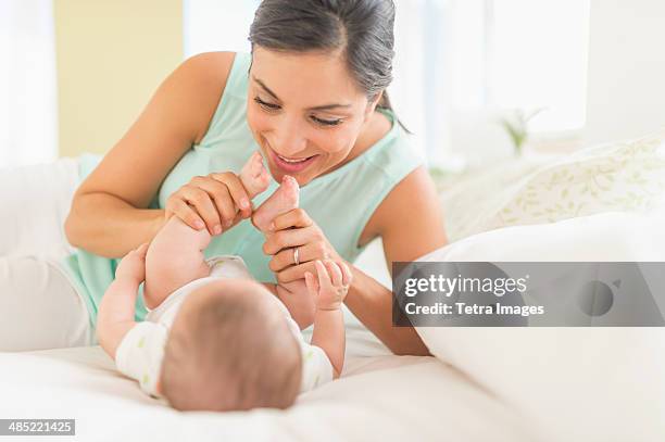 mother and baby (2-5 months) lying on bed - mexican and white baby stock pictures, royalty-free photos & images