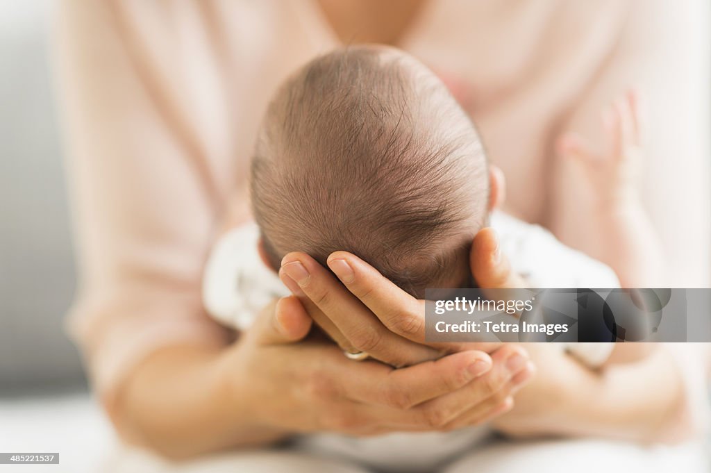 Mother holding baby boy (2-5 months)