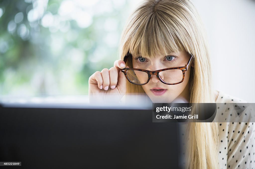 Woman wearing glasses working on computer