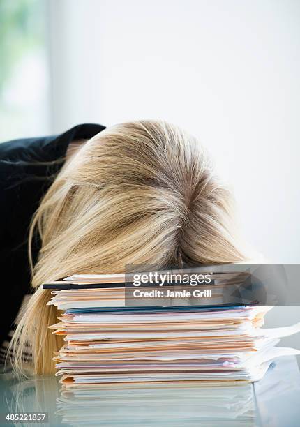businesswoman sleeping on stack of files - bored worker stock-fotos und bilder