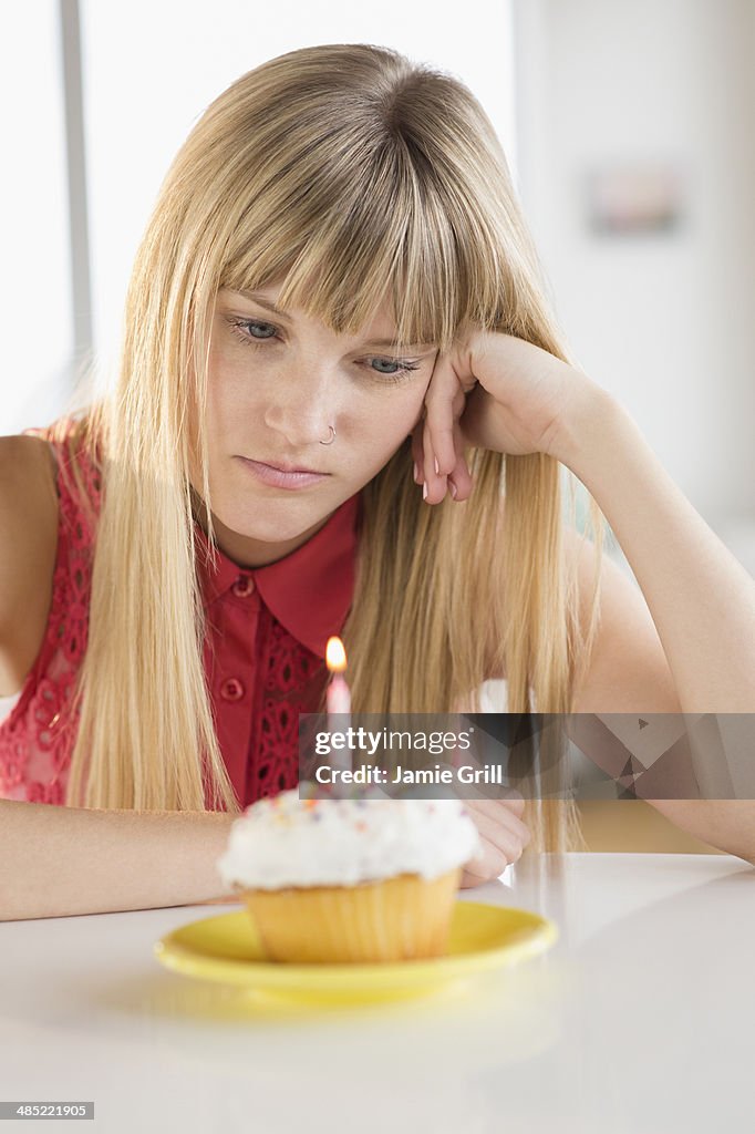Woman looking at birthday cupcake