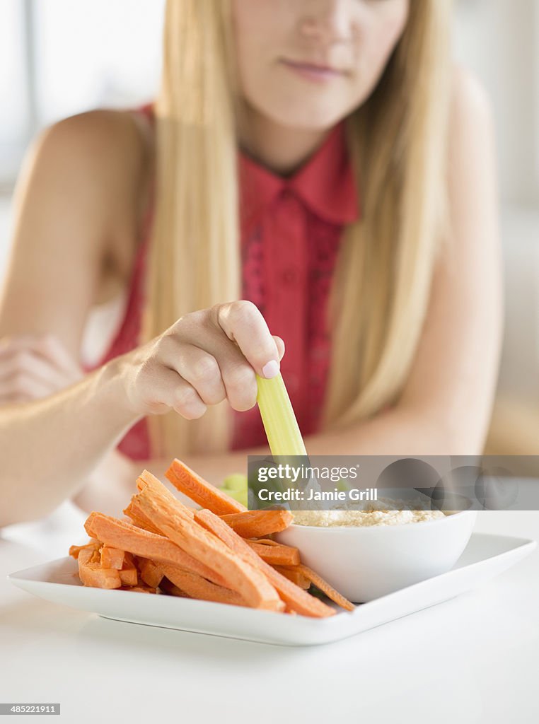 Woman dipping celery