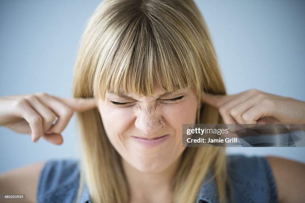 Woman blocking ears with fingers