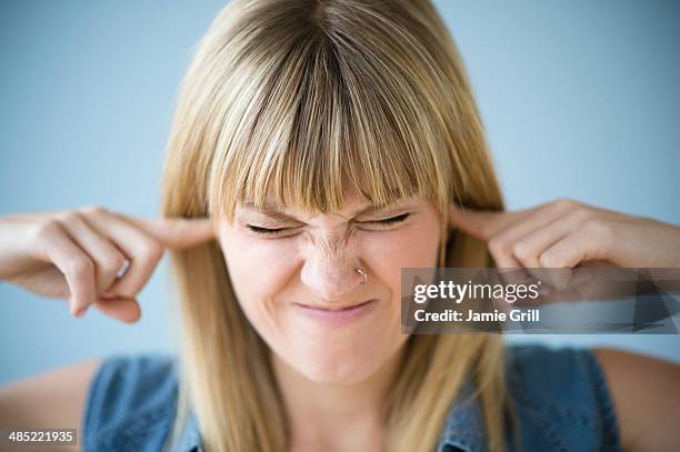 woman blocking ears with fingers - bad bangs imagens e fotografias de stock