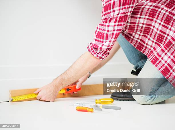 man measuring baseboard - skirting board stock pictures, royalty-free photos & images