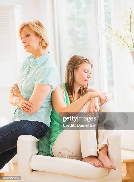 mother and adult daughter back to back - in the dog house stockfoto's en -beelden