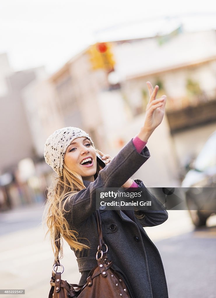 USA, New York City, Brooklyn, Williamsburg, Portrait of blond woman hailing cab