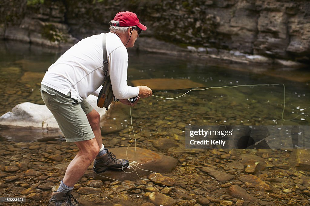 USA, Colorado, Fisherman on riverbank