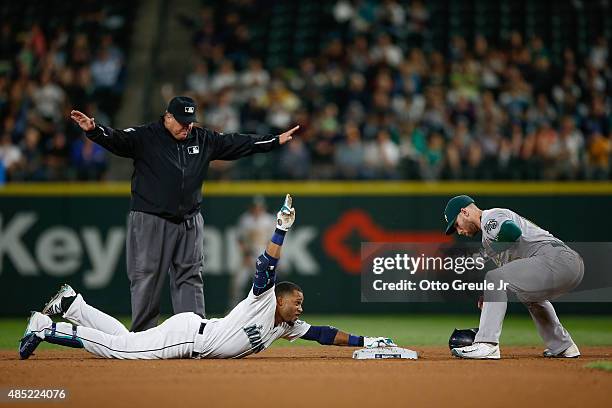 Robinson Cano of the Seattle Mariners gestures after doubling against second baseman Brett Lawrie of the Oakland Athletics in the seventh inning at...