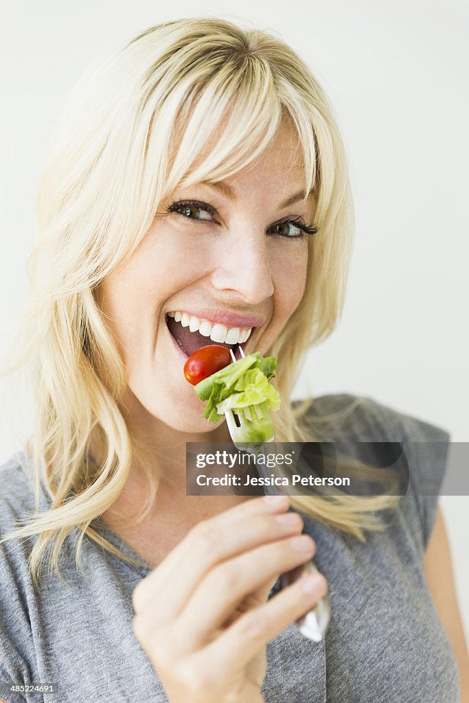 Woman holding salad on fork