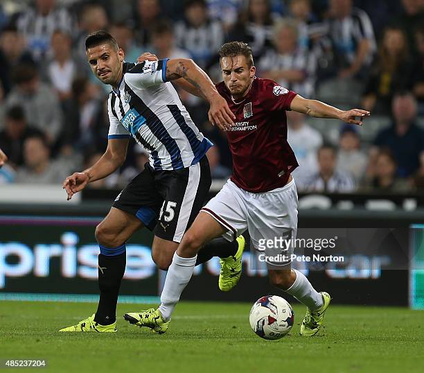 Lawson D'Ath of Northampton Town contests the ball with Aleksandar Mitrovic of Newcastle United during the Capital One Cup Second Round match between...