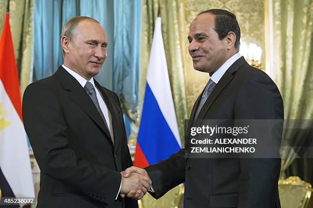 Russian President Vladimir Putin shakes hands with his Egyptian counterpart Abdel Fattah al-Sisi during a meeting at the Kremlin in Moscow on August...