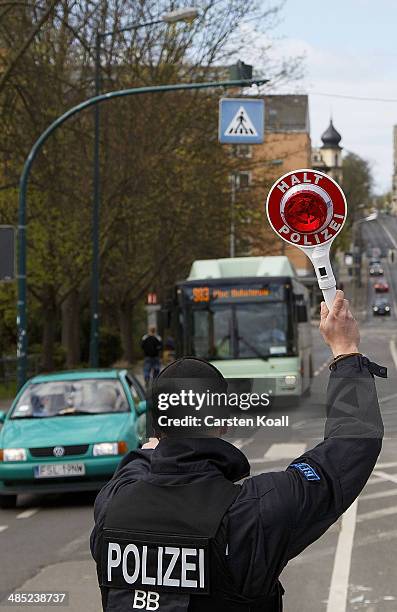 German policman holds a police signal stick to stop cars to check their vehicle papers and contents near the Polish border on April 15, 2014 in...